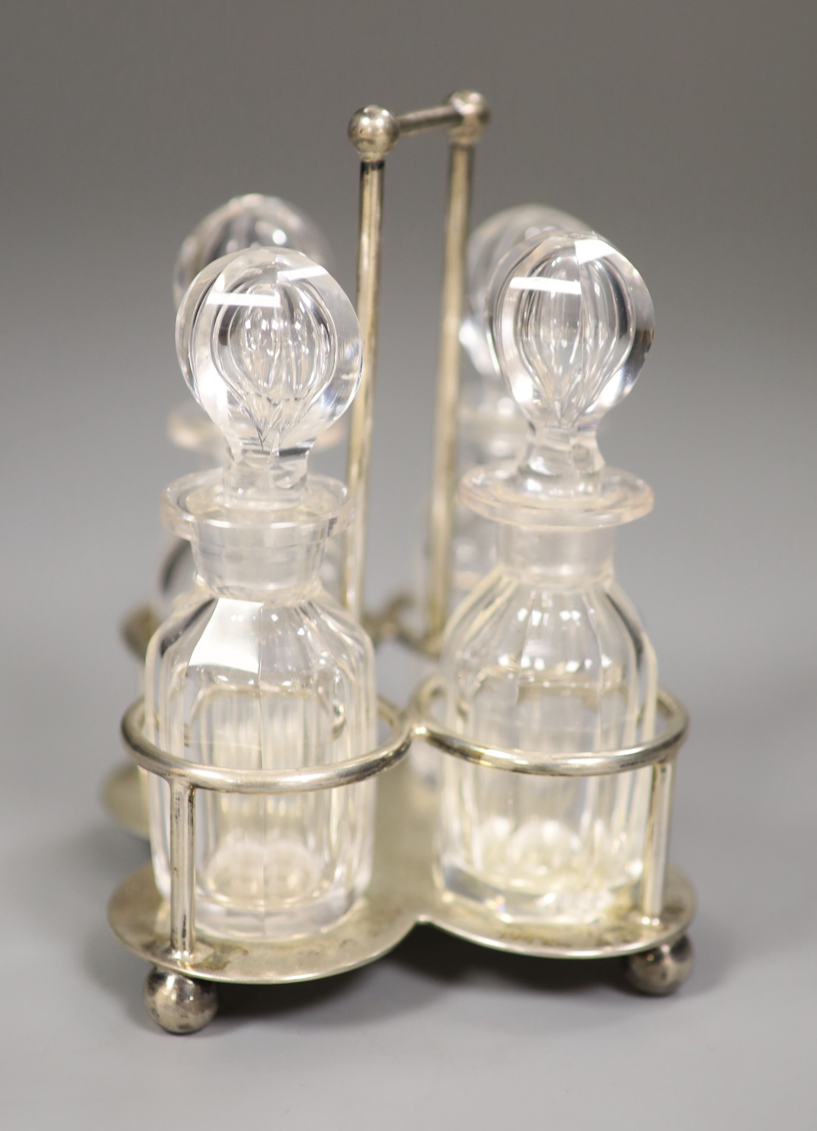 A small Edwardian silver cruet stand, with four glass cruets, Goldsmiths & Silversmiths Co Ltd, London 1901, height 12cm, 4oz.